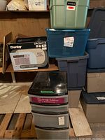 Stacked plastic storage bins and a drawer unit with an air conditioner box in background