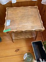 Top view of vintage wooden side table showing scalloped edge detail on the tray-like tabletop surface.