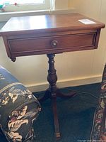 Front view of vintage solid mahogany Gibbard pedestal table with drawer, showing shape and drawer pull detail.