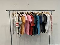 Full view of all cotton tops and t-shirts hanging on a clothing rack, showing range of colors and styles