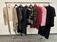 Full view of all 8 hanging clothing items on metal rack showing different styles and colors
