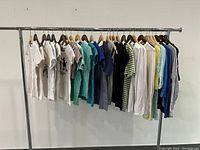 Wide view of all t-shirts and tops hanging on rack showing variety and quantity.