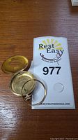 Front and back covers removed showing empty case halves and bezel ring on wood surface with lot number card