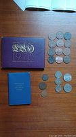 Purple folder with 1970 British coin set and assorted loose coins on wood surface
