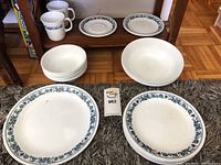 Full overhead view showing plates, bowls, and cups with blue floral trim on floor and shelf.
