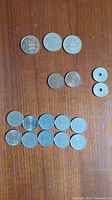 Top down view of all 17 Japanese coins arranged on wooden surface showing denominations and conditions.