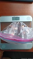 Plastic bag of pennies placed on a digital scale reading 10.2 pounds.