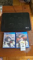 KLIM computer cooling fan on wooden table with two PS4 NHL game cases visible underneath