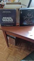 Photo of Star Wars soundtrack vinyl and Bach classical album on a wooden table, showing front covers.