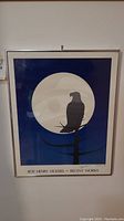 Full view of framed print hanging on wall showing eagle silhouette and moon design