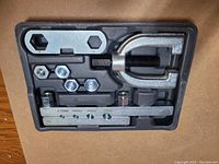 Top-down view of bubble flare kit components inside a black plastic case laid on a wooden surface.