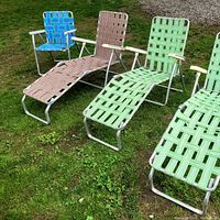 Four retro beach chairs and loungers arranged on grass showing detail and condition