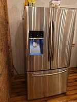 Front view of closed French doors showing stainless steel finish and water/ice dispenser