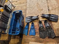 Top view of all flippers and breathing tubes arranged on a wooden surface showing all items clearly.