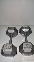 Pair of 40 lb cast iron hex dumbbells side by side showing condition and weight markings