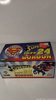 Front view of the box showing Superman, Jeff Gordon, and #24 branding along with logos of Action Diecast, Revell, and NASCAR