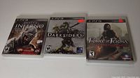 Front cases of Dante's Inferno, Darksiders, Prince of Persia PS3 games showing cover art and titles.