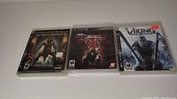 Photo showing three PS3 game cases: Conan, The Darkness 2, and Viking lined up side by side.