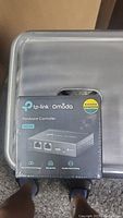 Top view photo of sealed TP-Link Omada OC200 hardware controller box with front label showing product name and ports.