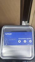 Photo of the Ortizan X10 wireless speaker box in blue with waterproof icon and Bluetooth symbol.