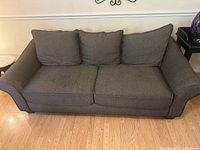 Front view of black/white herringbone pattern sleeper sofa with three back cushions and two seat cushions on wood floor