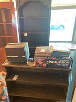 Display of all items on a wooden surface near a window demonstrating the lot contents including boxes and the projector partially enclosed.