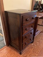 Side and front view of the wooden lingerie chest showing four drawers with two round knobs each, dark wood finish.