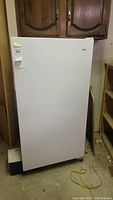 Front view of Kenmore upright freezer, showing overall size and shape, with visible stains and dirt on the white exterior.