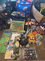 Photo showing assorted boys' toys including Melissa and Doug wooden pegboard game, dinosaur plush toys, toy sword, basketball, Captain America shield helmet, collapsible hamper, and growth chart.