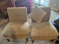 Pair of side chairs upholstered in geometric patterned fabric, showing overall front view with one chair having a matching cushion.