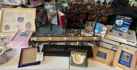 Photo showing a variety of photo frames, decorative pieces including a wooden and metal item with candle holders, smaller wood and glass decor.