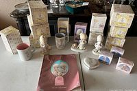 Full lot overview showing boxed figurines, multiple collectibles, mugs and reference book