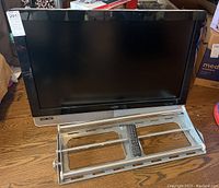 Vizio flat screen TV with included wall mount and remote shown on wooden floor.