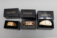 Three Joan Rivers ladies watches in original black boxes, arranged side by side showing overall appearance and packaging.
