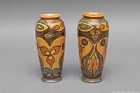 Pair of Art Deco Clews & Co. chameleonware pottery bud vases showing front and side views with detailed color patterns.