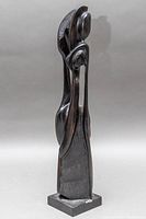 Left side view of the sculpture showing the abstract forms and textured details on top.