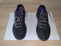 Top view showing front and laces of both shoes on a wooden floor