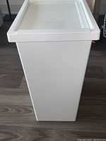 Full view of the white plastic storage bin showing its rectangular shape and lid.