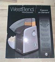Box exterior showing the West Bend Professional Popcorn On Demand machine image and branding.