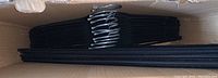 Box containing 16 slim black velvet hangers with chrome hooks stacked neatly inside.