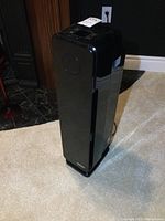 Full view of black Germ Guardian air cleaner showing shape, size, and cord.