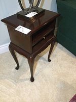 Front view of the Bombay side table showing the top, open compartment, slide out shelf, drawer, and cabriole legs.