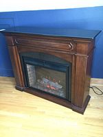 Front view of the electric fireplace showing wooden frame and granite top.