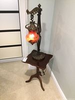 Full view of the ornate hanging lamp placed on the Bombay tilt-top table showing height, color and design details