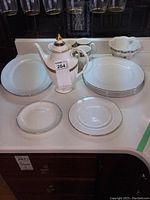 Full view of the china set showing plates, teapot, and Jello mould bowl arranged on the counter