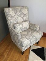 Side-angle view of the armchair showing patterned fabric upholstery and cushion.
