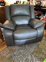 Front view of gray Ashley rocker recliner chair showing padded arms and cushioned backrest.