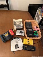 Photo of cameras, Panasonic electronic devices and manuals on a table