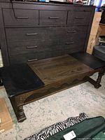 Photo of the front and top of wooden coffee table with black marble inset panels