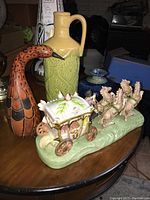 Wide view showing all items including the green vase, gourd bird figurine, and horse carriage figurine
